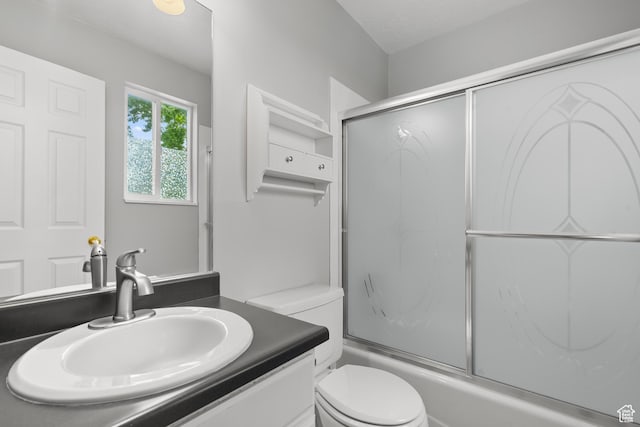 full bath with toilet, combined bath / shower with glass door, and vanity