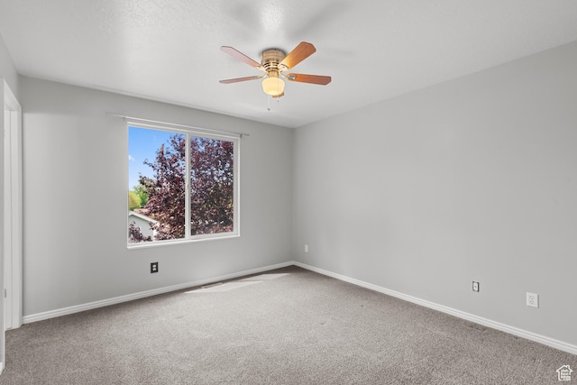 carpeted empty room with ceiling fan and baseboards