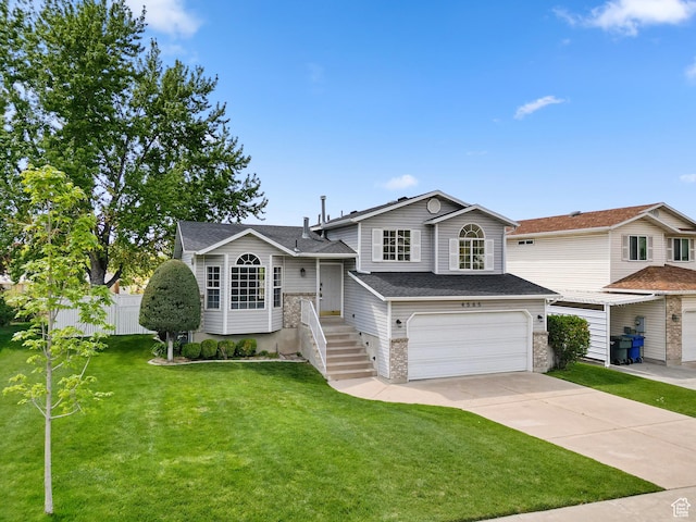 split level home featuring a garage, concrete driveway, and a shingled roof