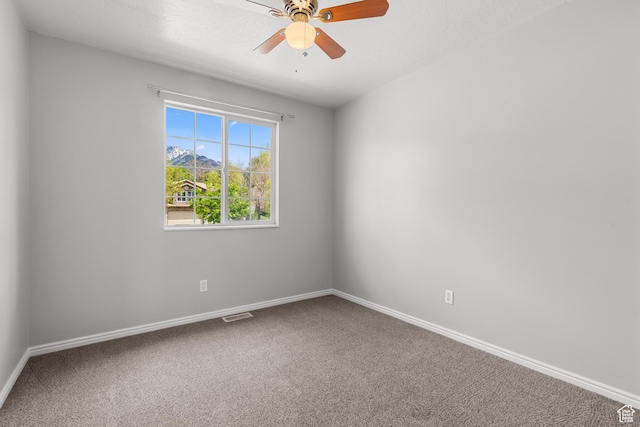 spare room with carpet, a ceiling fan, and baseboards
