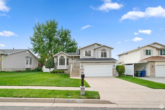 tri-level home with a garage, driveway, and a front lawn