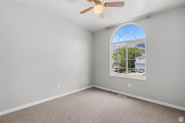 unfurnished room featuring ceiling fan, carpet flooring, baseboards, and a textured ceiling