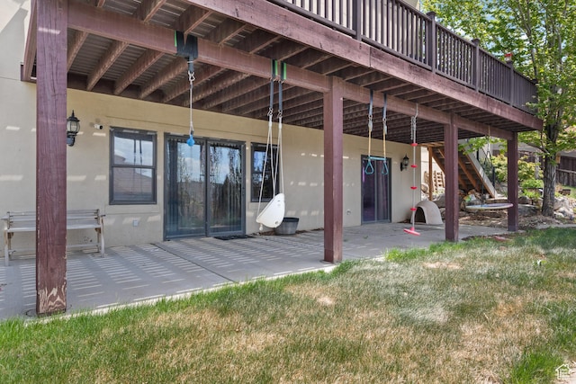rear view of house featuring a patio area, stairway, and stucco siding