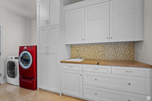 laundry area featuring cabinet space, washing machine and clothes dryer, and bar with sink