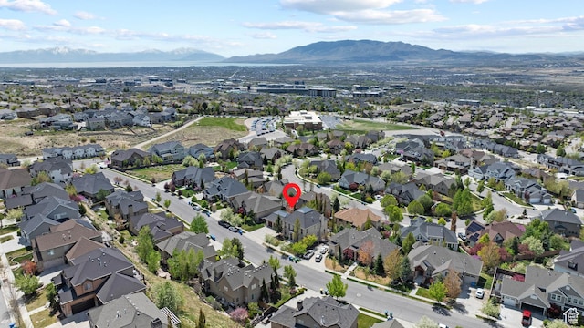 aerial view of property and surrounding area featuring mountains and nearby suburban area