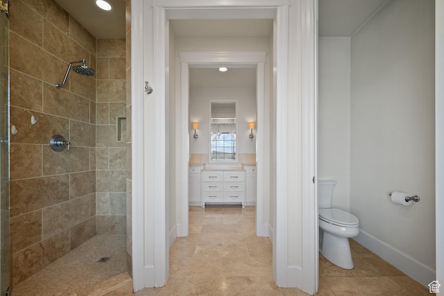bathroom with a shower stall, toilet, and baseboards