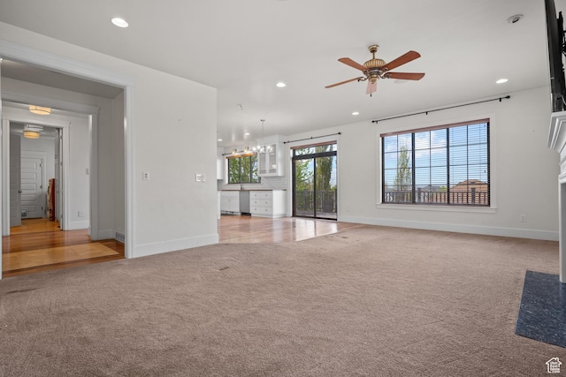 unfurnished living room featuring light colored carpet, a ceiling fan, baseboards, and recessed lighting