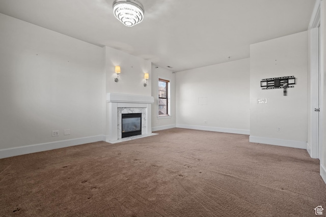 unfurnished living room featuring carpet floors, a fireplace, and baseboards