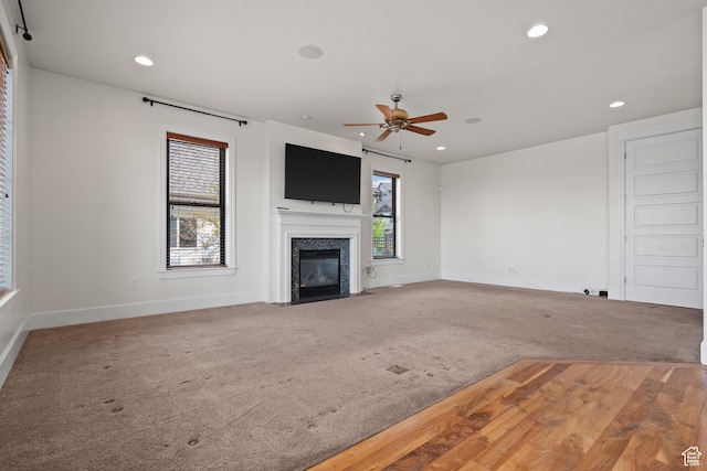 unfurnished living room featuring carpet, baseboards, a ceiling fan, and recessed lighting