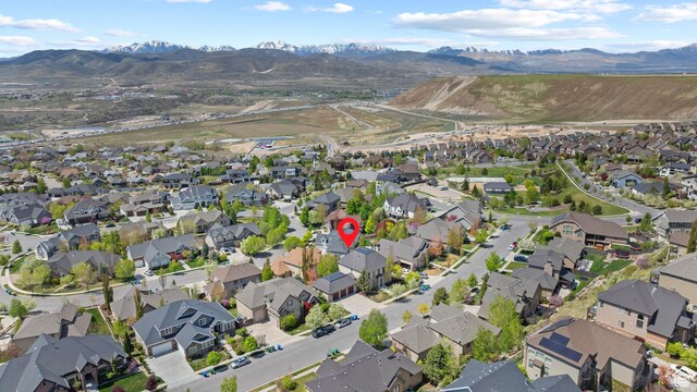 aerial view of property and surrounding area featuring nearby suburban area and a mountain backdrop