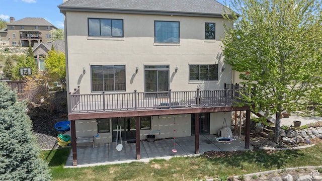 back of house with a patio area, stucco siding, a deck, and a shingled roof