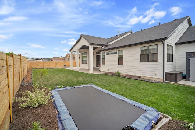 rear view of house with a patio and a shingled roof