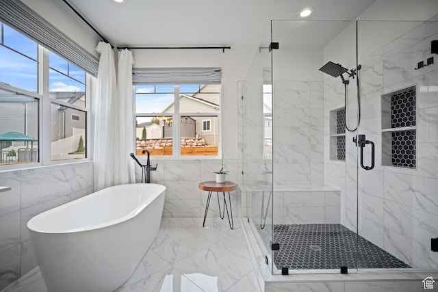 bathroom featuring marble tiled flooring, a soaking tub, a stall shower, tile walls, and recessed lighting