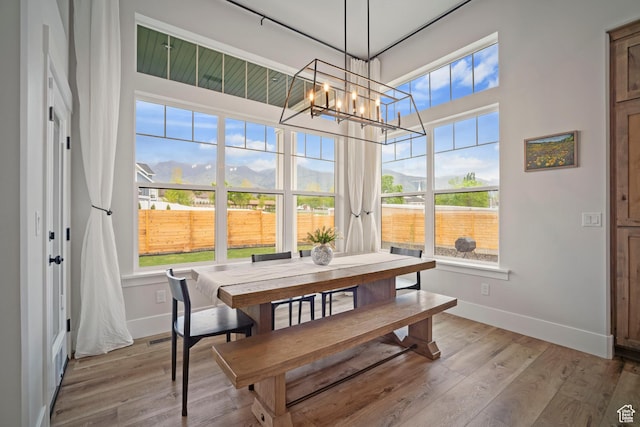dining room with a chandelier, baseboards, and wood finished floors