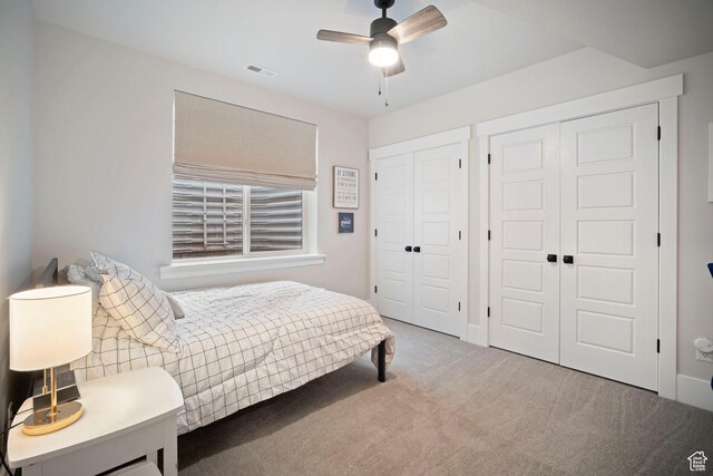 carpeted bedroom with multiple closets and ceiling fan