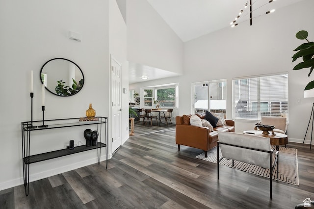 living room featuring wood finished floors, high vaulted ceiling, and baseboards
