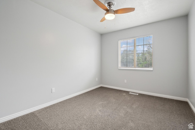 unfurnished room with baseboards, a ceiling fan, and dark colored carpet