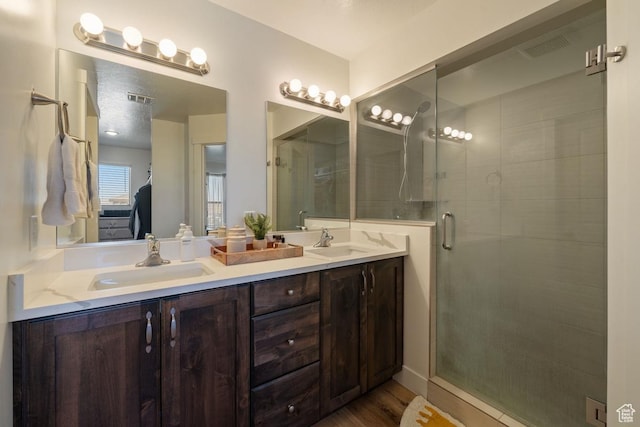6303 S Zelda Dr, St George, UT 84790 - bathroom with a stall shower, double vanity, and wood finished floors