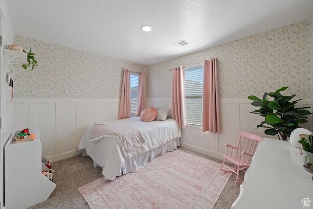 6303 S Zelda Dr, St George, UT 84790 - bedroom featuring wainscoting, a decorative wall, wallpapered walls, and carpet