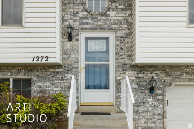 entrance to property featuring brick siding