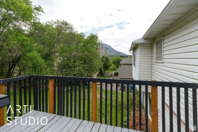 wooden terrace featuring a mountain view and a lawn