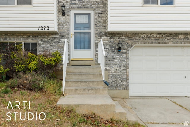 property entrance with a garage and stone siding