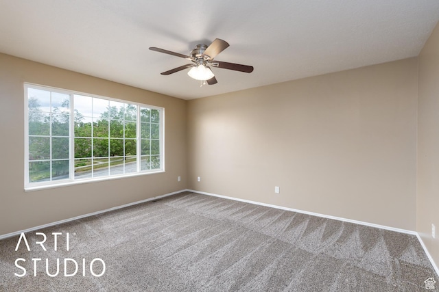 carpeted empty room featuring baseboards and a ceiling fan