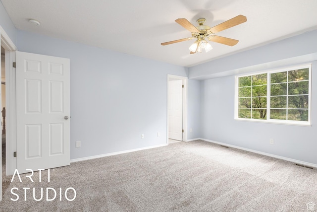 carpeted empty room featuring baseboards and ceiling fan
