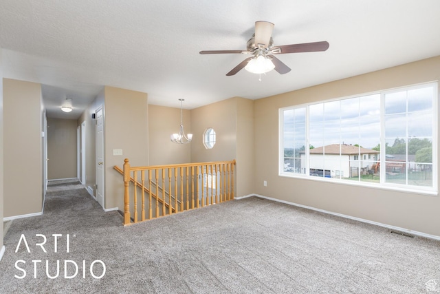 unfurnished room featuring carpet floors, a chandelier, baseboards, and ceiling fan