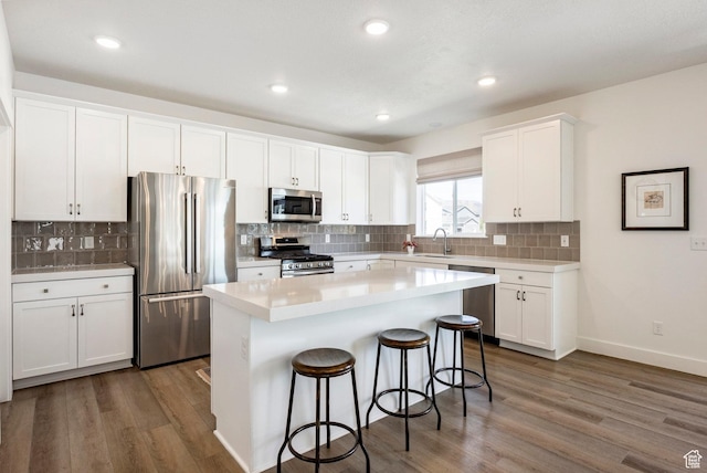 1401 S 1040 E, Heber City, UT 84032 - kitchen featuring appliances with stainless steel finishes, a sink, a breakfast bar, white cabinets, and wood finished floors