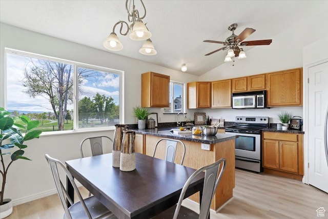 155 W 1525 N, Layton, UT 84041 - kitchen with stainless steel appliances, dark countertops, healthy amount of natural light, brown cabinetry, and lofted ceiling