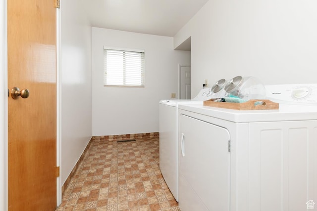 laundry area with separate washer and dryer, baseboards, and light flooring