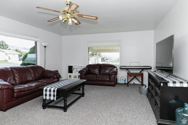 living area with light carpet and ceiling fan