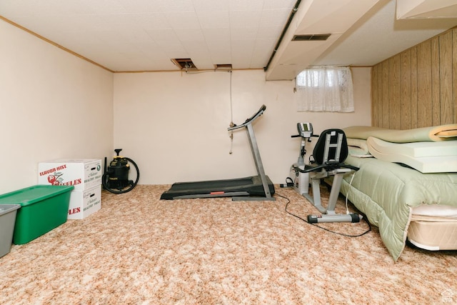 bedroom with carpet floors and wooden walls