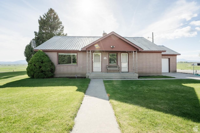 view of front of property featuring covered porch, brick siding, a garage, and a front yard