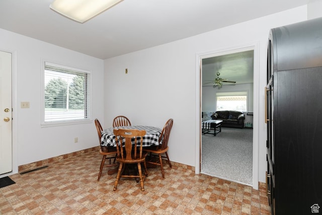 dining area with baseboards, light floors, and ceiling fan