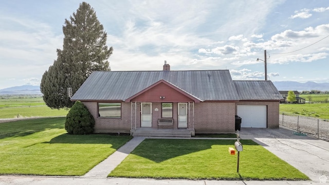 view of front of home featuring brick siding, a garage, a mountain view, concrete driveway, and metal roof