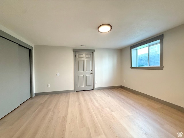 spare room with light wood finished floors and baseboards