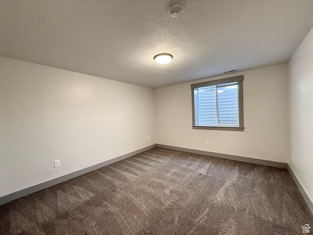 carpeted empty room featuring baseboards, a textured ceiling, and a smoke detector