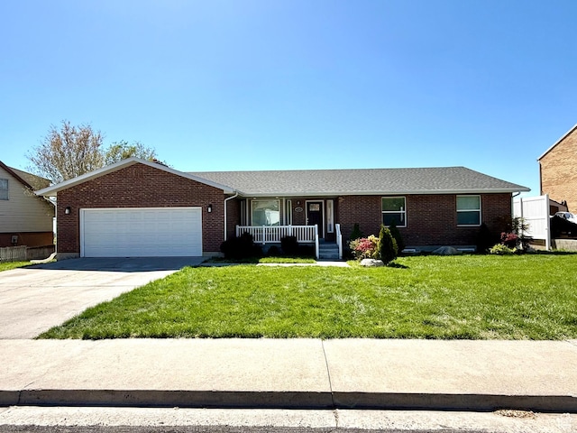 single story home featuring an attached garage, a porch, a front yard, driveway, and brick siding