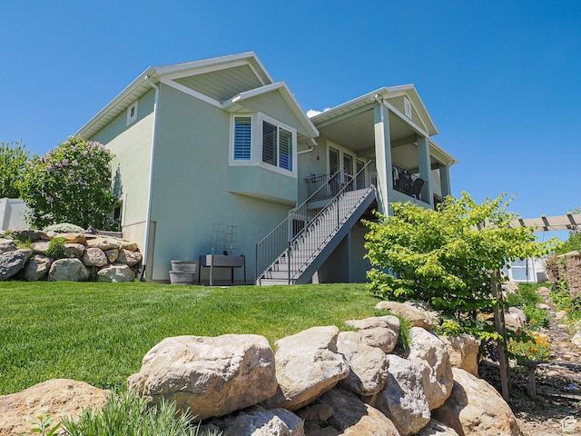 7503 S Bridge Maple Ln, West Jordan, UT 84081 - view of home's exterior with stairs, a lawn, and stucco siding