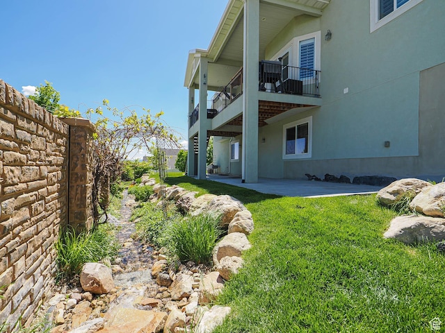 7503 S Bridge Maple Ln, West Jordan, UT 84081 - view of green lawn with a balcony and a patio