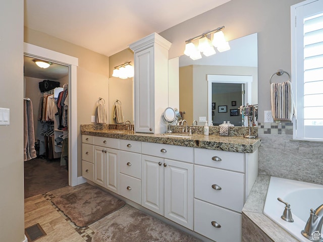 7503 S Bridge Maple Ln, West Jordan, UT 84081 - full bathroom with vanity, a bath, and a walk in closet