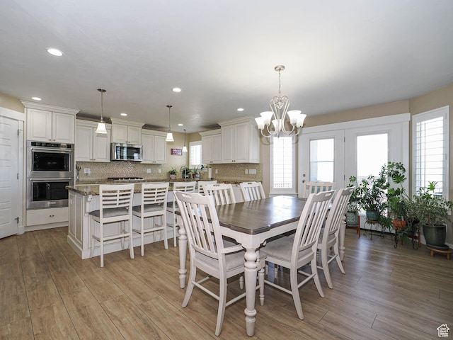7503 S Bridge Maple Ln, West Jordan, UT 84081 - dining room featuring healthy amount of natural light, a chandelier, light wood finished floors, and recessed lighting