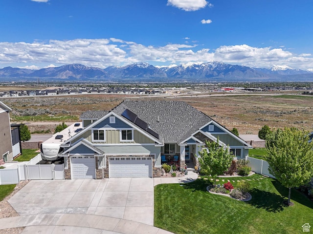7503 S Bridge Maple Ln, West Jordan, UT 84081 - view of front facade with board and batten siding, driveway, stone siding, a mountain view, and an attached garage