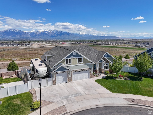 7503 S Bridge Maple Ln, West Jordan, UT 84081 - view of front facade featuring stone siding, driveway, a mountain view, board and batten siding, and a gate