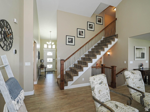 7503 S Bridge Maple Ln, West Jordan, UT 84081 - foyer entrance with wood finished floors, a towering ceiling, a chandelier, baseboards, and stairs