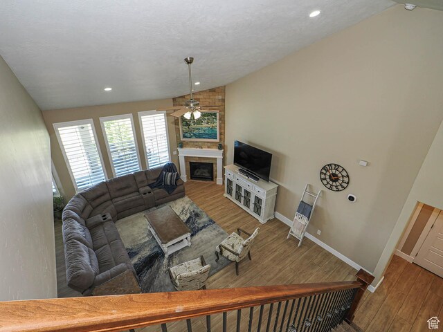7503 S Bridge Maple Ln, West Jordan, UT 84081 - living room featuring vaulted ceiling, ceiling fan, a large fireplace, wood finished floors, and baseboards