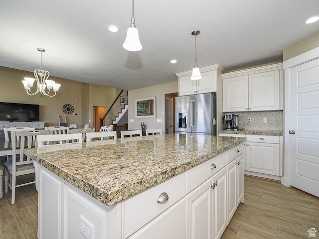7503 S Bridge Maple Ln, West Jordan, UT 84081 - kitchen with high end fridge, light wood-type flooring, a center island, pendant lighting, and a chandelier