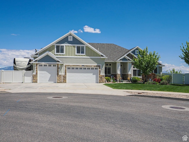 7503 S Bridge Maple Ln, West Jordan, UT 84081 - craftsman inspired home with stone siding, driveway, a garage, board and batten siding, and a gate